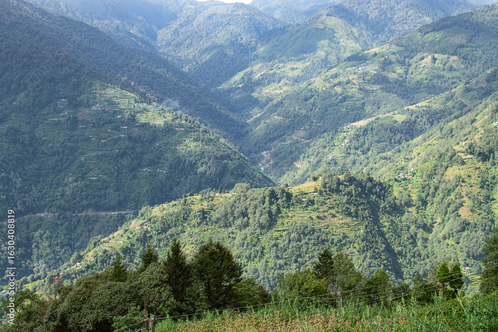 Naklejka premium Sun rays falling on Himalayan mountain range, scenic beauty of layers of mountains, Okhrey, sikkim, India. Okhrey village a remote place in Sikkim where mountain range view is enjoyed by tourists.