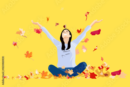 Colorful maple leaves fall on a woman sitting in the yoga pose Sukhasana. A woman enjoys autumn life in nature.