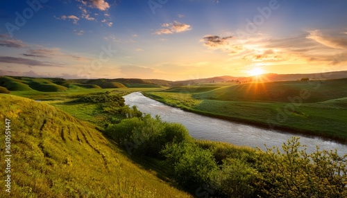 a serene landscape featuring a flowing river lush green fields and a radiant sunset casting golden hues over the horizon creating a tranquil and picturesque natural scene