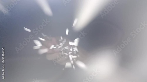 White rice grains falling from an open hand in mid-air, cascading gently downward like rain, each grain catching soft light as it moves