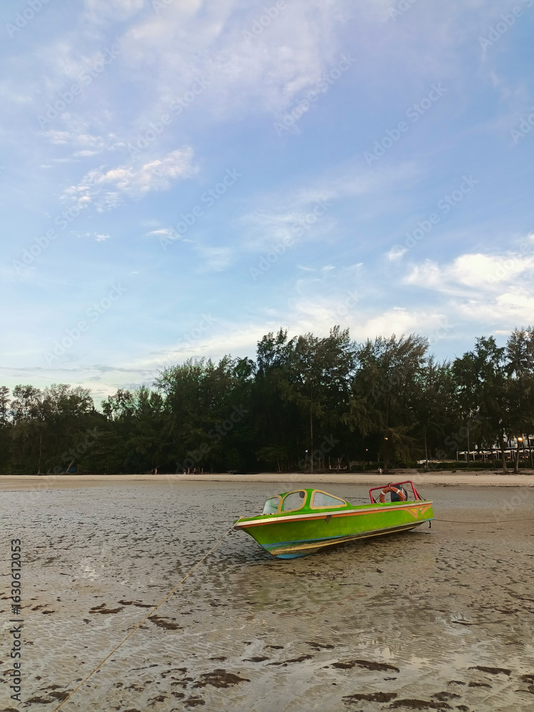 Fototapeta premium A fishing boat on the receding beach.