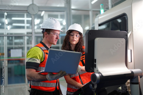 Obraz na plátně Engineers inspect and maintain a train in a repair facility during the afternoon