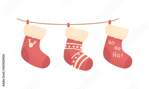 Three Christmas socks on a rope with different patterns. Christmas home decorations. New Year elements