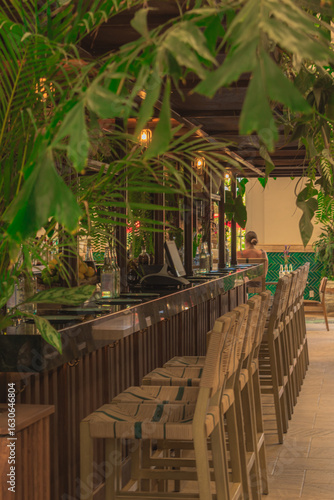 Tropical Bar Interior with Wooden Stools and Green Plants – Modern Resort Lounge