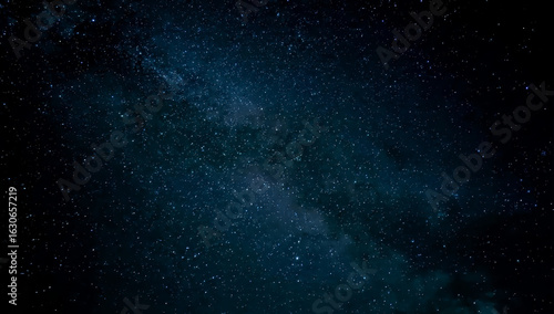 Galaxy exploration through outer space towards glowing milky way galaxy. High quality, beautiful night sky time lapse with Milky Way galaxy on dark sky. Starry night background.