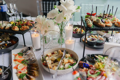 Catering service on banquet table with canape snacks in restaurant or hotel. Decorated food set on birthday, wedding celebration or business conference event venue