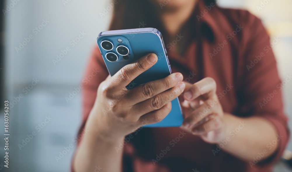 Fototapeta premium Closeup image of a businesswoman using mobile phone in office