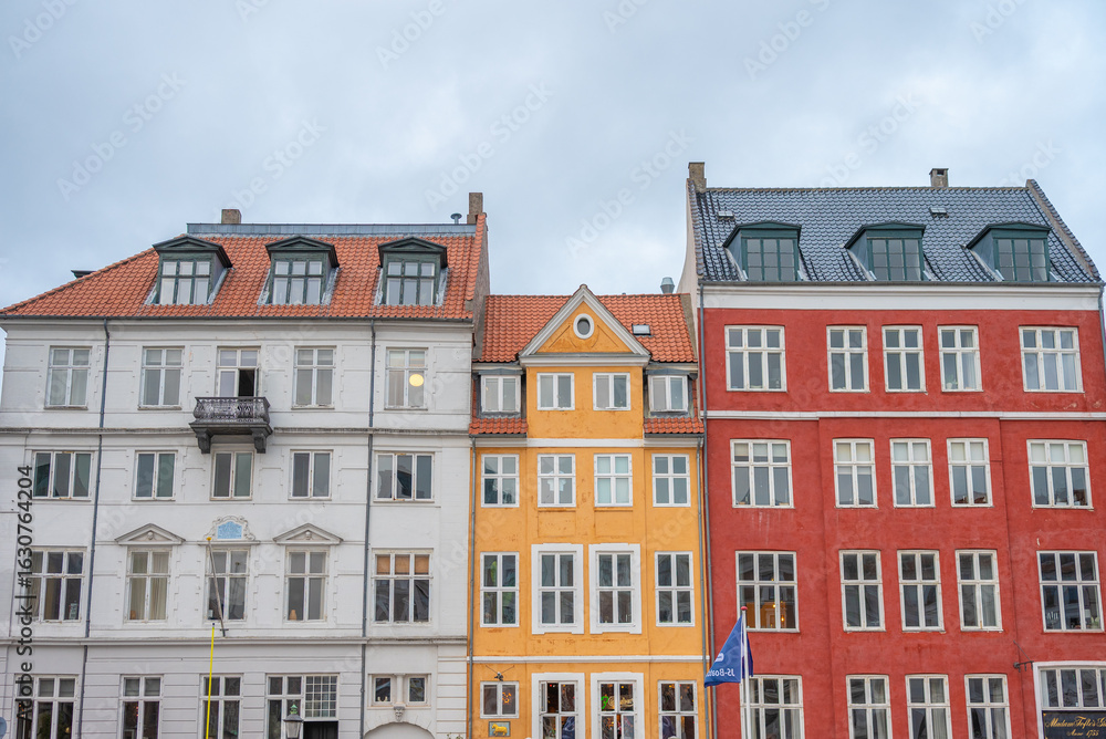 Fototapeta premium Les maisons colorées sur les rives du canal Nyhavn, au cœur de la ville de Copenhague au Danemark