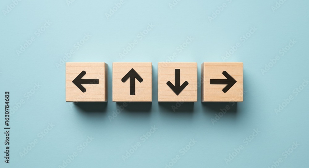 Obraz premium Four Wooden Blocks with Directional Arrows on Blue Background