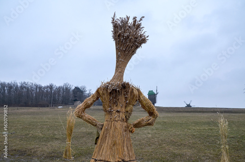 фотографія Traditional Ukrainian straw effigy (Didukh) stands in a vast, dry field under a