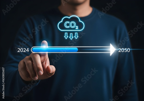 Man tracks carbon emissions progress from 2024 towards a cleaner 2050 future on futuristic display