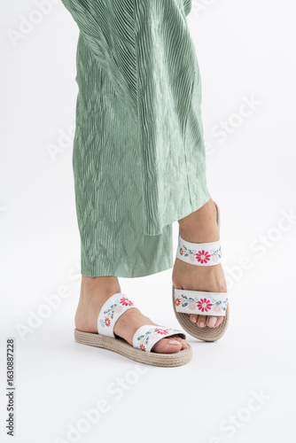 Sandalias planas de esparto con tiras bordadas de flores y pantalón plisado
