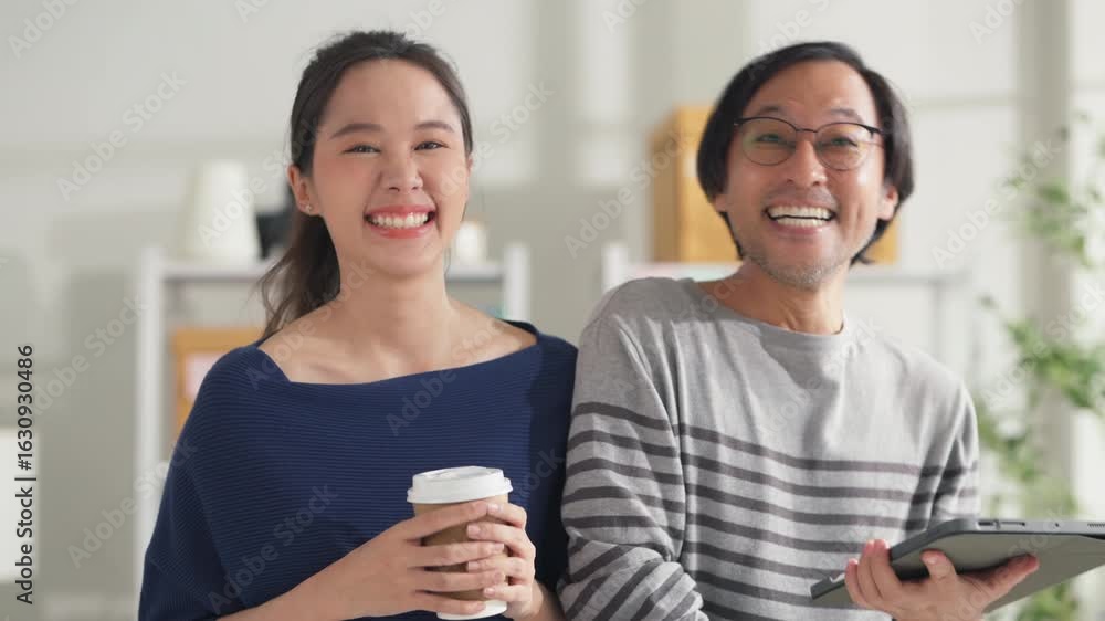 business portrait smiling asian businessman and woman partner standing fun happiness positive goodvibes confident look at cemra in modern interior home studio workshop playful businesspeople business portrait smiling asian businessman and woman partner standing fun happiness positive goodvibes confident look at cemra in modern interior home studio workshop playful businesspeople