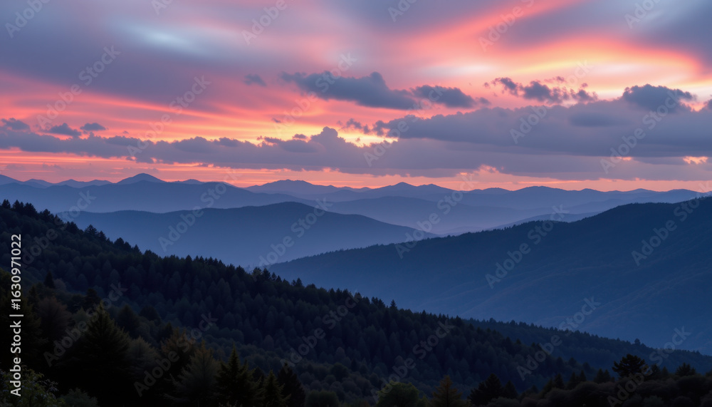 Obraz premium Breathtaking sunset over rolling mountains, showcasing vibrant hues of pink and orange against backdrop of layered peaks and lush forests. serene landscape evokes sense of tranquility and wonder