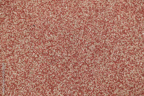 A texture background of red soft rubber safety flooring from a playground or running track