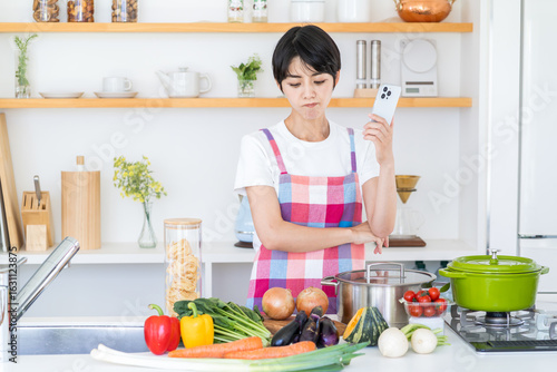 野菜をみながら、レシピを探す主婦。