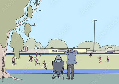 Two adults watching children play winter hockey game from sidelines