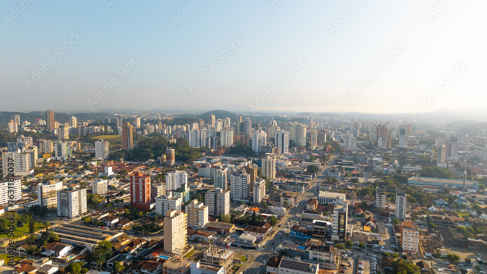 Fototapeta premium Aerial cityscape of Joinville, Santa Catarina, Brazil, featuring tall buildings and urban sprawl under clear skies.