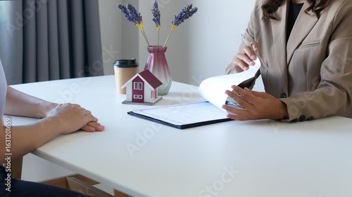 Businesswoman real estate agent signs documents and gives home insurance advice Create a home purchase insurance contract to approve the purchase for the customer.