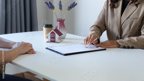 Businesswoman real estate agent signs documents and gives home insurance advice Create a home purchase insurance contract to approve the purchase for the customer.