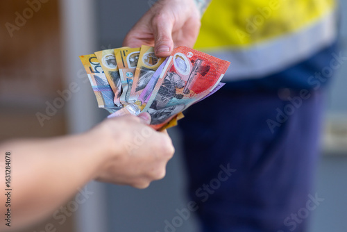 cash transaction taking place with a handful of cash being handed to another