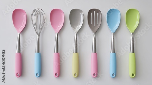 Kitchen utensils with colorful silicone handles arranged on a light background