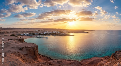 夕陽が輝く砂漠の入り江、穏やかな海と白い建物が美しい景色を織りなす