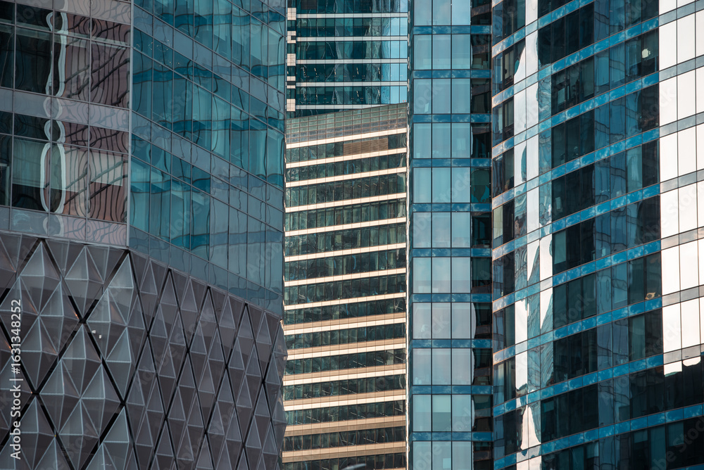 Fototapeta premium mirrored windows of the facade of an office building with blue panels