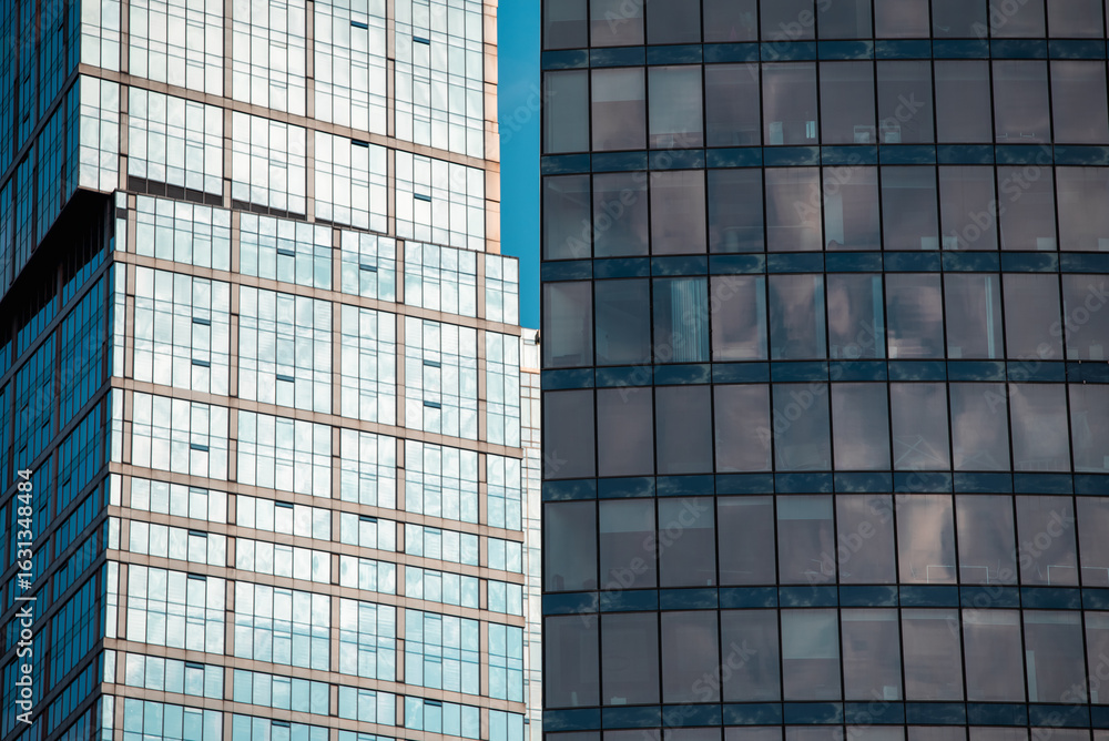 Obraz premium mirrored windows of the facade of an office building with blue panels
