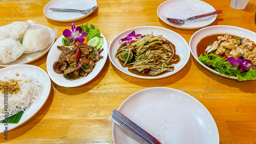 A set of original Northeastern Thai food or Isaan food, local food including Papaya salad, Spicy grilled pork salad , Slide grilled pork salad, Spicy Squid Salad.