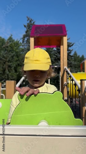 Little boy playing on a swing. Child on a playground, small kid playing outdoor