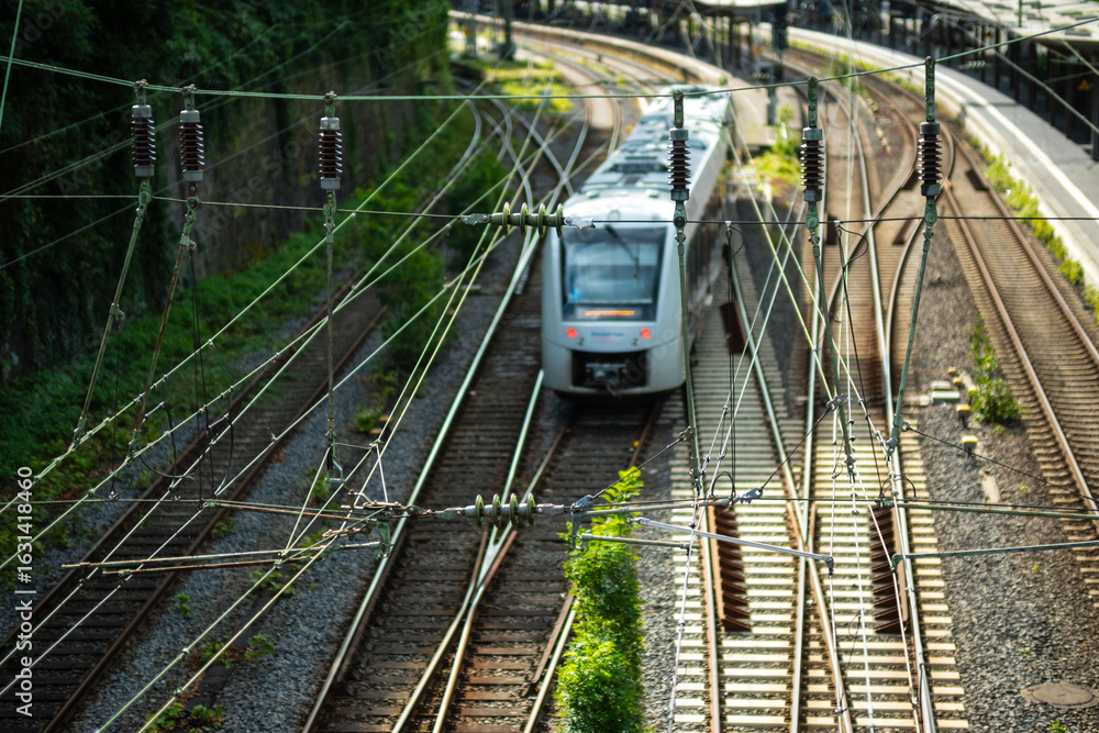 Fototapeta premium Oberleitungen und Gleise mit Zug am Bahnhof in Wuppertal, Deutschland