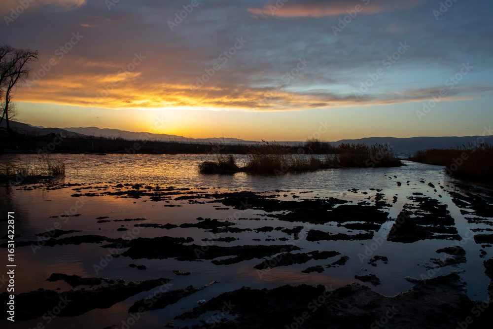 Fototapeta premium Sunset at Utah Lake with dark shoreline and glowing sky reflections