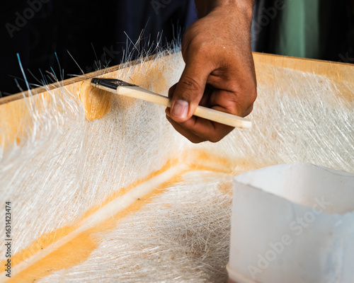 Foto Brushing fiberglass sheets on a wooden box