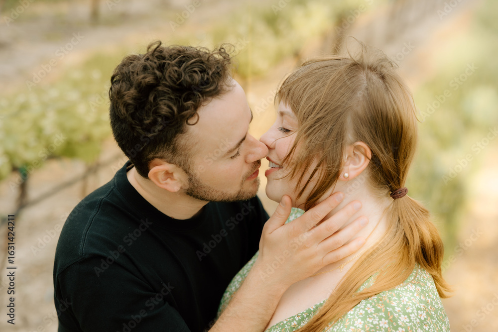 Couple kissing in vineyard during wine tasting celebration Couple kissing in vineyard during wine tasting celebration