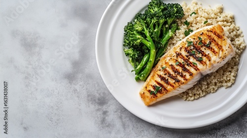 Single white plate with perfect portion of grilled fish, millet, and broccolini, negative space
