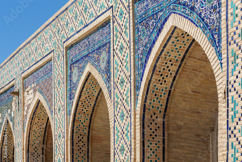 Colorful Islamic mosaic tile arches of Kalon Mosque in Bukhara, Uzbekistan under clear blue sky