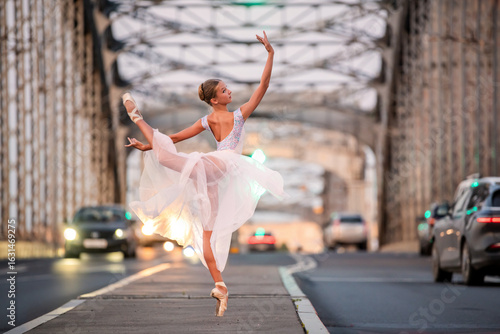 Young ballet student girl dancing on city bridge