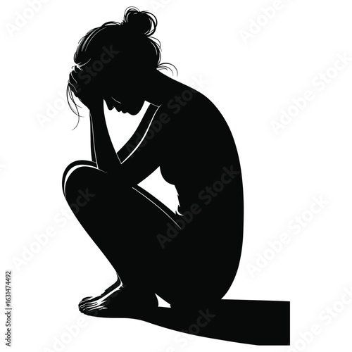 Sad woman crouching with head in hands silhouette