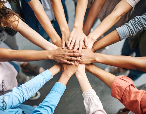 Diverse group of people join hands in a circle, symbolizing unity and teamwork
