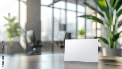 Wallpaper Mural White empty business card is standing on a wooden table in a blurred modern office with plants and sunlight Torontodigital.ca