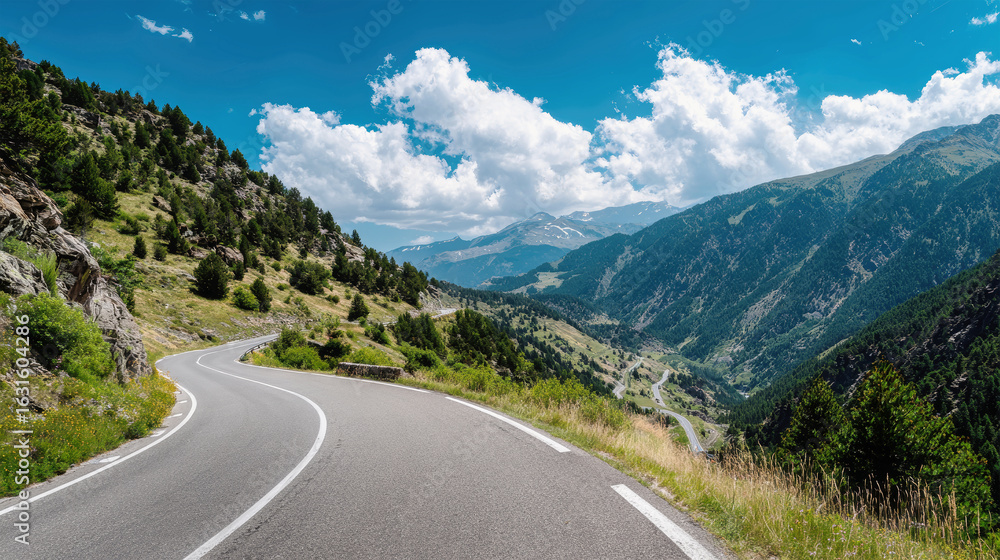 Naklejka premium Winding mountain road offers breathtaking views of lush greenery and stunning blue skies across serene landscape
