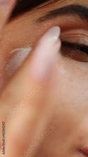 Close-up of a person applying a nourishing cream to their skin. This routine enhances their complexion while starting the day with a refreshing skincare ritual.