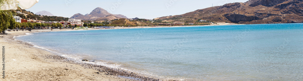 Fototapeta premium Panoramic View of a Sandy Beach and Turquoise Sea in Crete, Greece