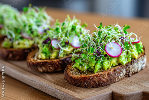 Food+and+beverage Fresh avocado spread toasted bread topped with vibrant microgreens and radish slices creates delightful food and beverage