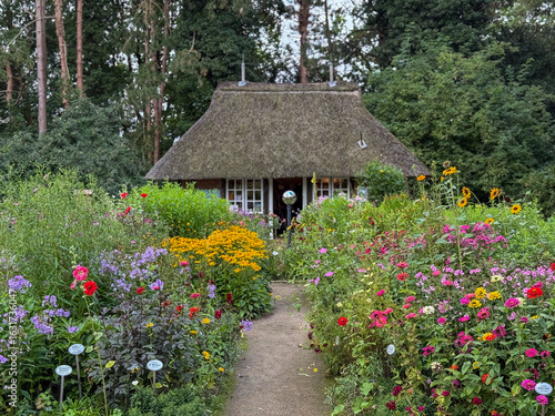 Stunning view of beautiful blooming botanical garden park Loki Schmidt with colorful flowers, trees  and garden shop building on cloudy summer day