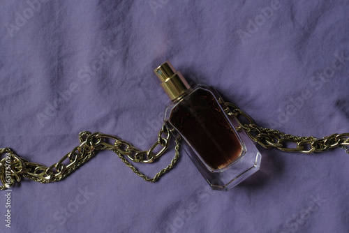 perfume bottle with brown liquid on a purple background