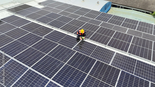 Worker conducts maintenance on solar panels atop a commercial building during midday