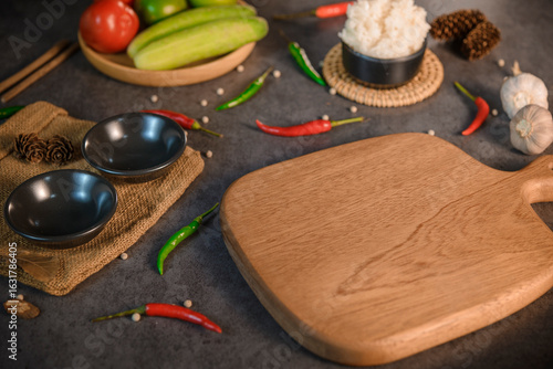 Empty wooden cutting board with empty cups around it. Food background, Thai food background.