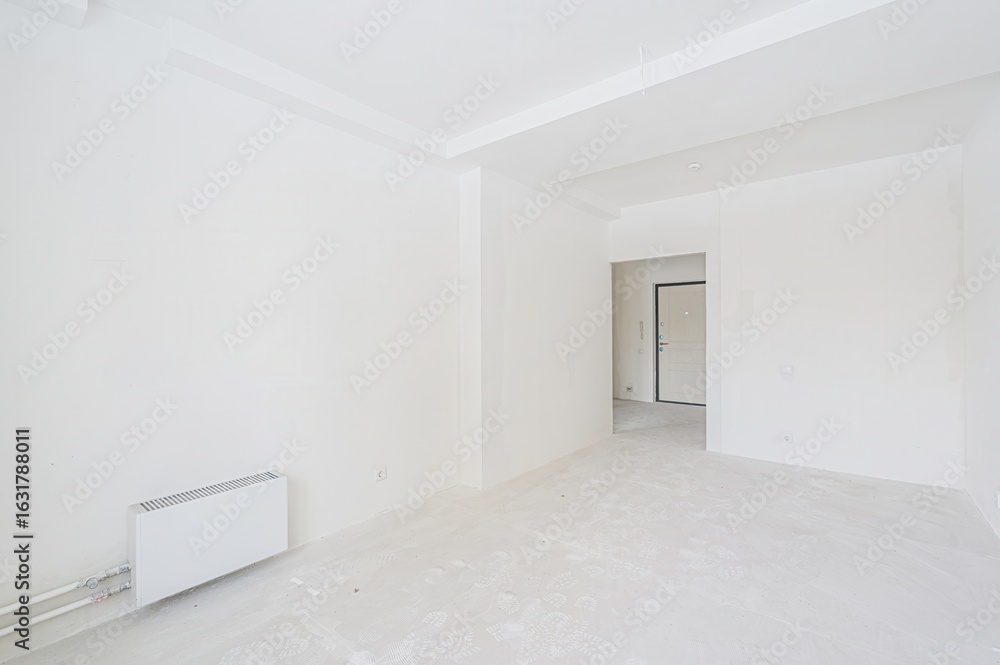 Obraz premium bright, empty room painted entirely white. A door frame is visible
